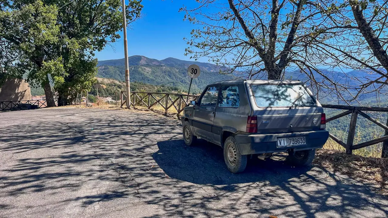 Starý Fiat Panda zaparkovaný u vyhlídky nad údolím