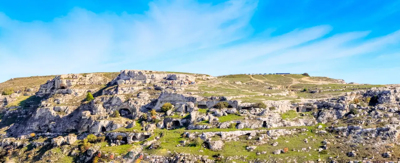 Přírodní park Murgia Materana na protějším svahu kaňonu Gravina s jeskyněmi a skalními kostely naproti Sassi di Matera