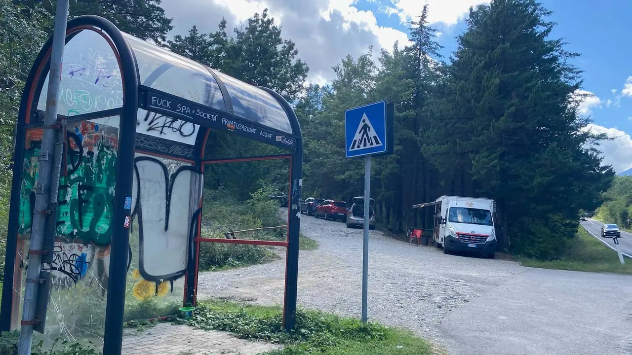 Poničená autobusová zastávka s graffiti u křižovatky v Bagni San Filippo, kde jsme hledali cestu k termálním pramenům.