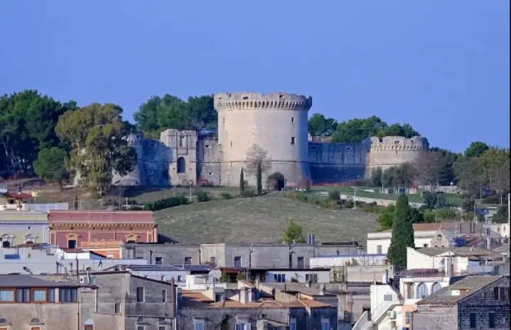 Panoramatický pohled na nedokončený hrad Castello Tramontano s třemi věžemi na kopci Lapillo nad kamenným městem Sassi di Matera