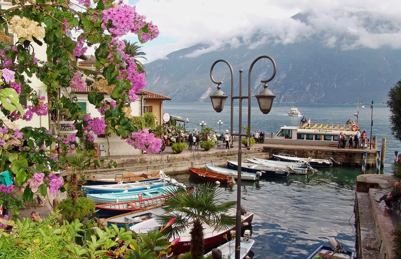 Historický přístav Porto Vecchio v Limone sul Garda s malebnými loďkami a výhledem na jezero Garda.