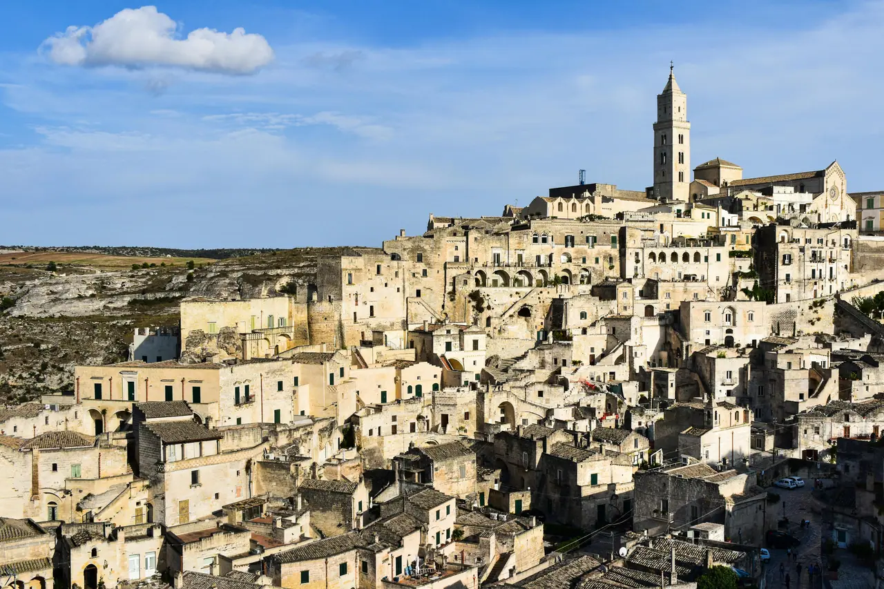 Scenic view of Matera's ancient stone buildings under a blue sky.
