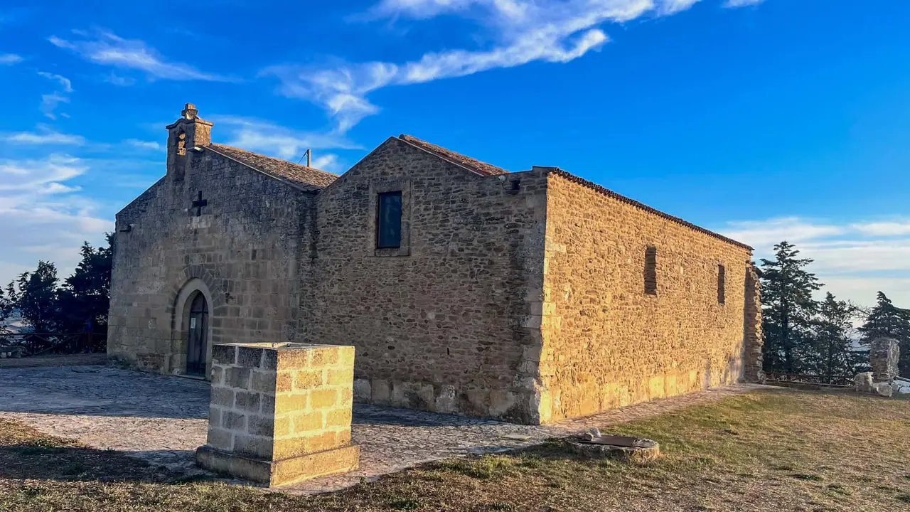 Kamenná kaple na Timmari osvětlená ranním sluncem, pohled z boční strany
