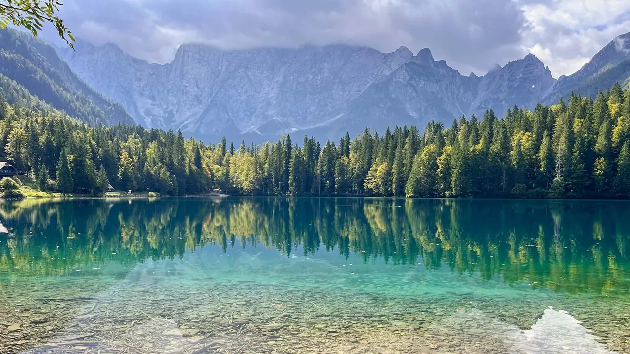 Detailní výhled na Lago di Fusine Inferiore s lesy a horským pozadím