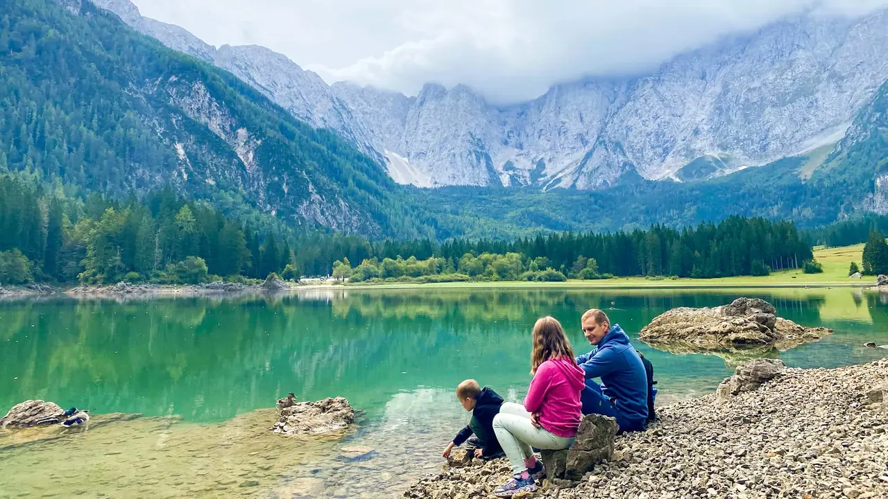 Rodina u tyrkysového jezera Fusine pod horami