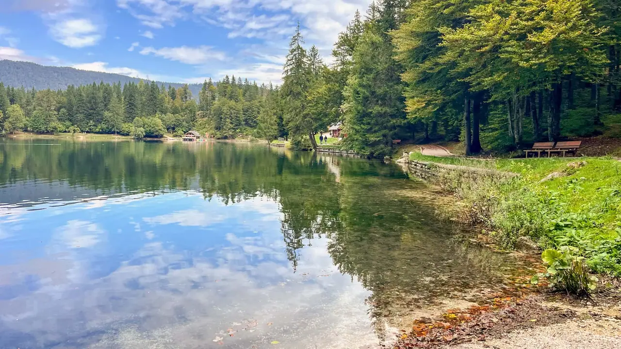 Ranní pohled na klidné Lago di Fusine Inferiore v Julských Alpách
