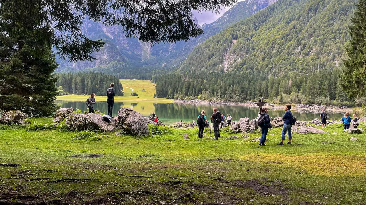 Turisté mezi Lago di Fusine Superiore a Inferiore při slunečném dopoledni