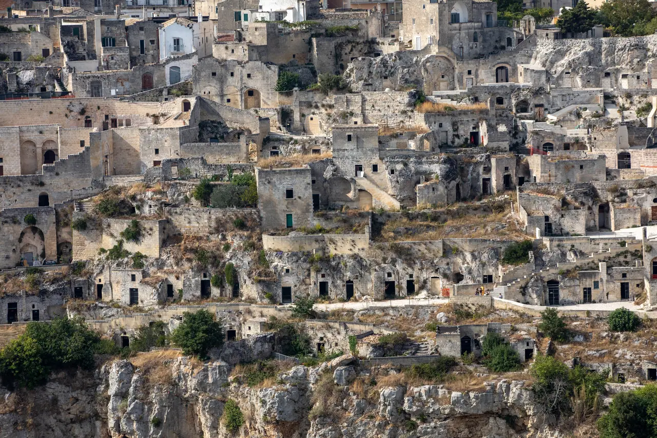 Vrstvené kamenné domy čtvrti Sassi di Matera, kde střechy tvoří dvorky pro domy nad nimi