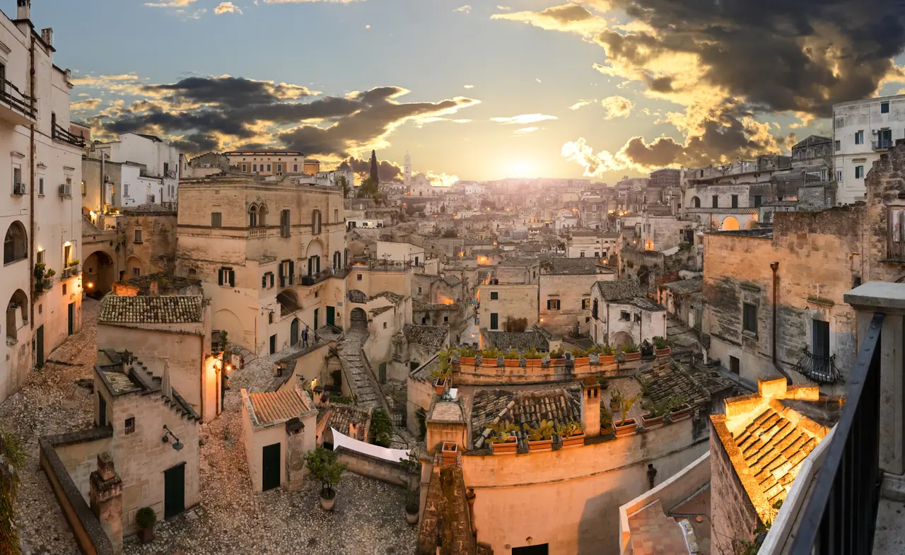 Večerní pohled na Sassi di Matera zalité zlatým světlem zapadajícího slunce