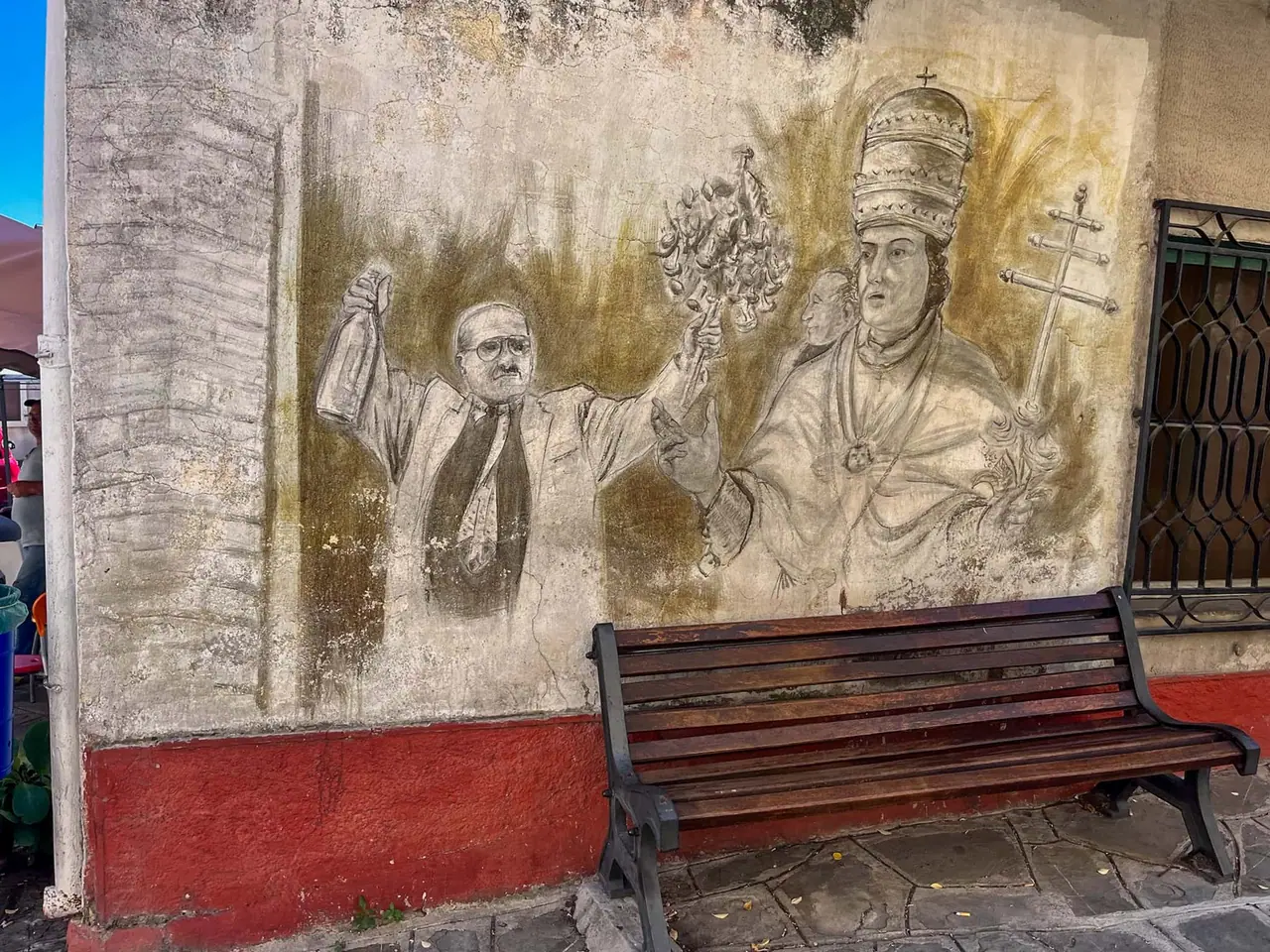 Murál s papežem a knězem na Piazza Municipio v Alessandria del Carretto