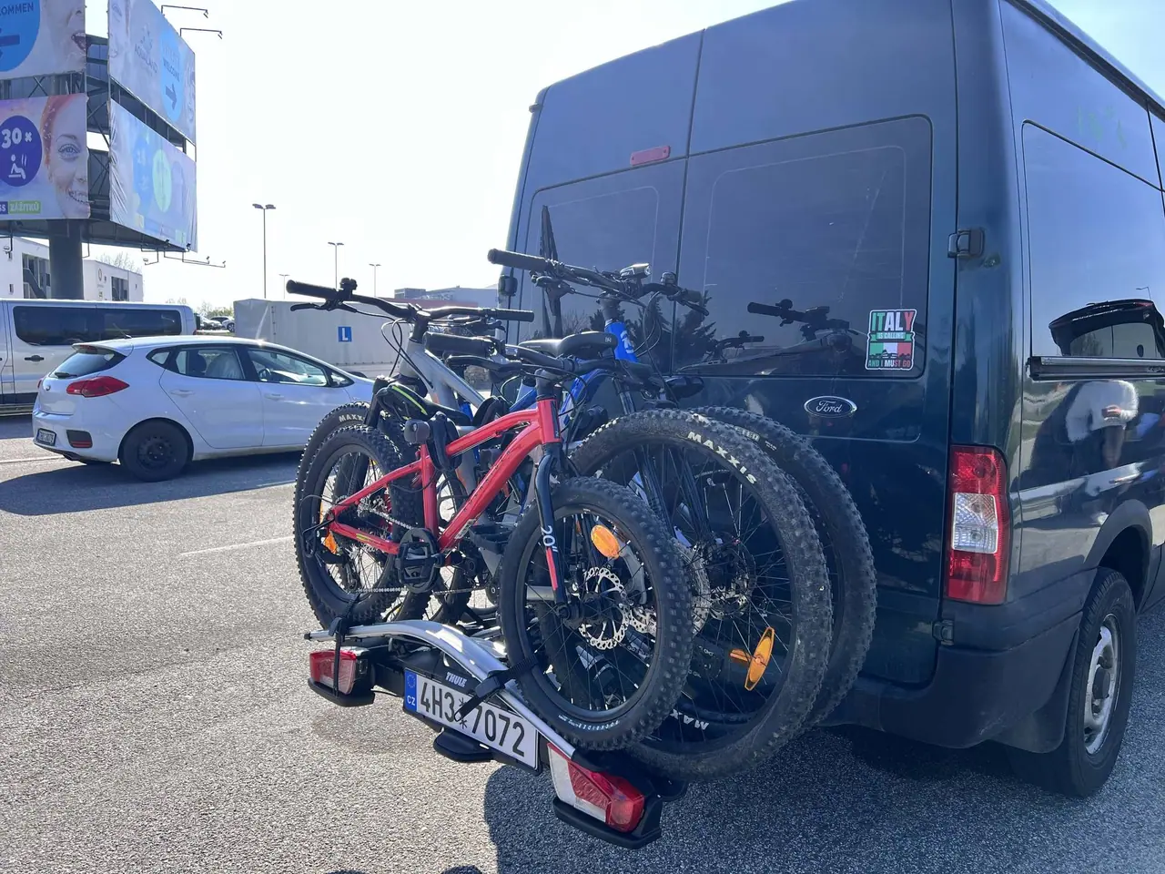 Náš nosič Thule VeloCompact se čtyřmi horskými koly na zadní části tmavé Ford dodávky během cesty po Itálii