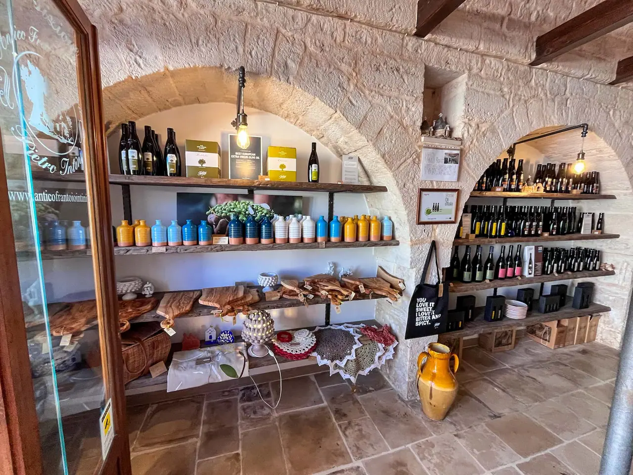 Interiér obchodu s olivovým olejem Intini a místními víny v kamennném trullo prostoru v Alberobellu