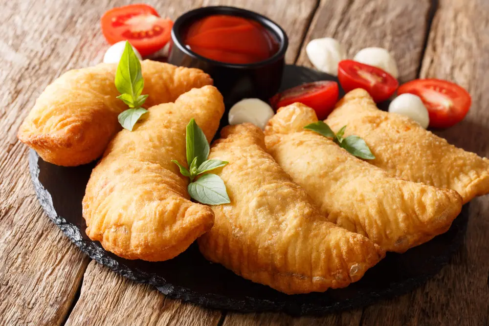 Smažený panzerotto plněný rajčaty a sýrem jako tradiční pochoutka z Vieste, Itálie