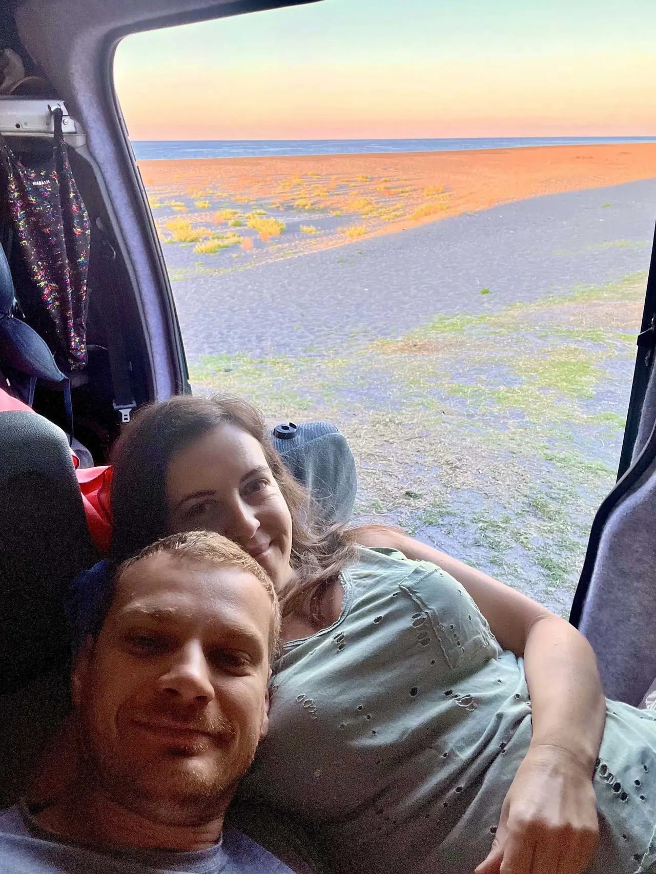 Selfie z dodávky na parkovišti u pláže Falerna Scalo při západu slunce, kdy obloha září oranžově nad mořem