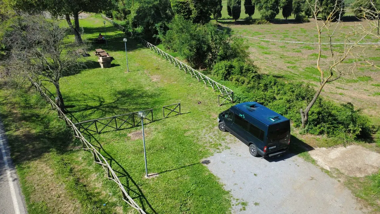 Naše dodávka zaparkovaná na travnatém parkovišti před mostem vedoucím do starobylé Civita di Bagnoregio