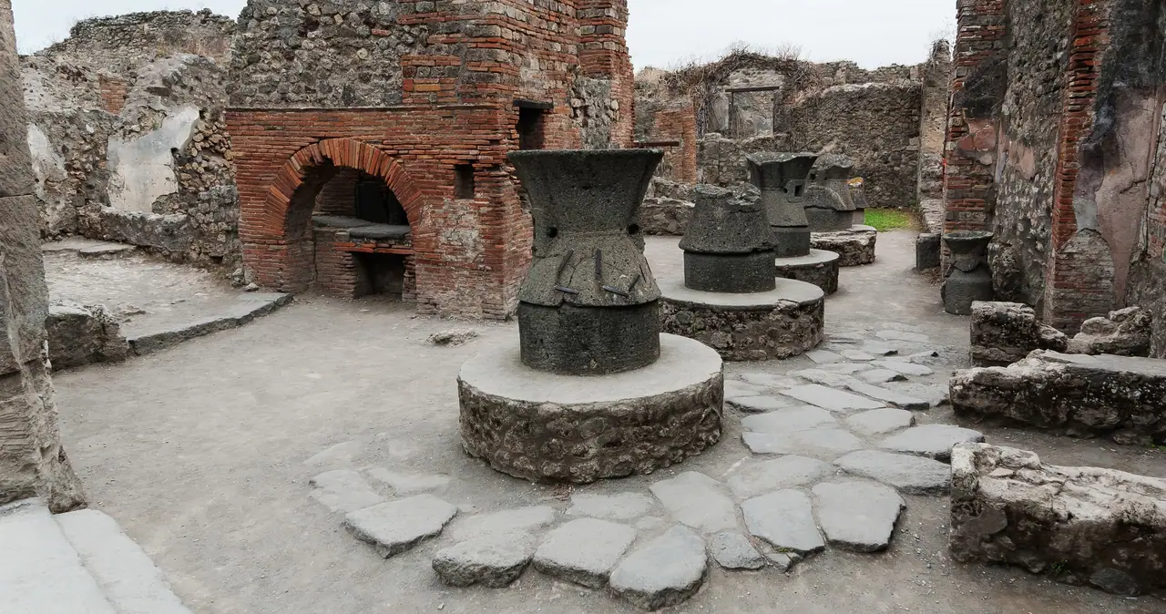 Zachovalá pekárna v Pompejích s kamenným mlýnem a pecí