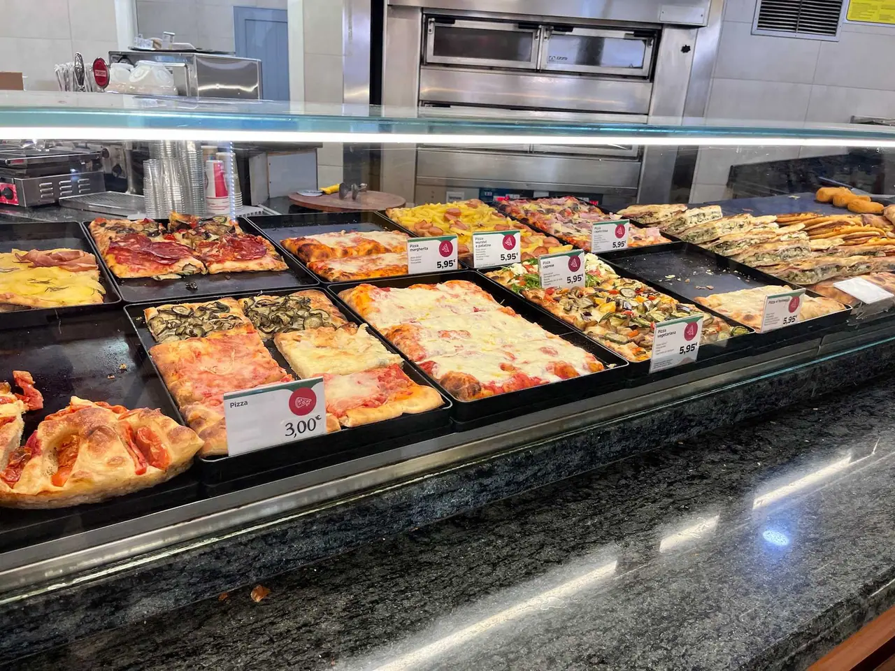 Vitrina s čerstvými pizzami v sanmarínské pizzerii - různé druhy za 3 až 6 eur, poslední zastávka před cestou domů