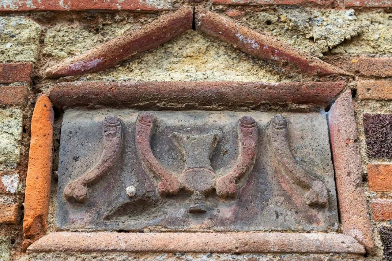 Symbol falického tvaru na zdi domu v Pompejích