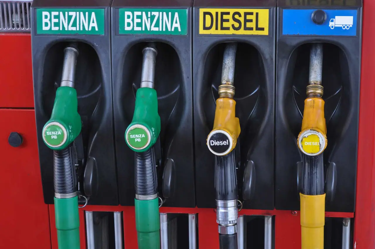Čtyři výdejní pistole na italské čerpací stanici – dvě zelené pro benzín bez olova a dvě žluté pro diesel pro osobní i nákladní auta.