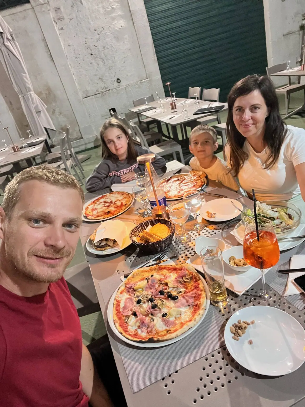 Rodinná večeře v pizzerii v Castellana Grotte - monča nikolka filda a já u stolu s italskými pizzami, nápoji a tradičními pokrmy