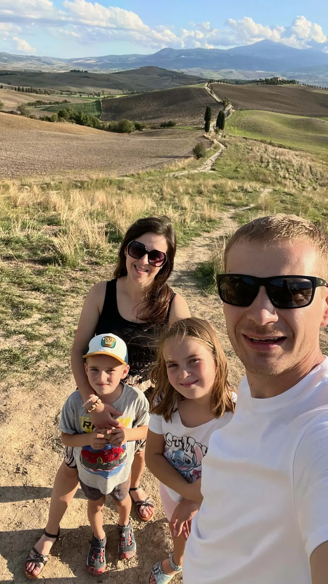 Naše rodinná selfie na toskánských kopcích s cypřiši a zlatavými poli, které připomínají scény z filmu Gladiátor