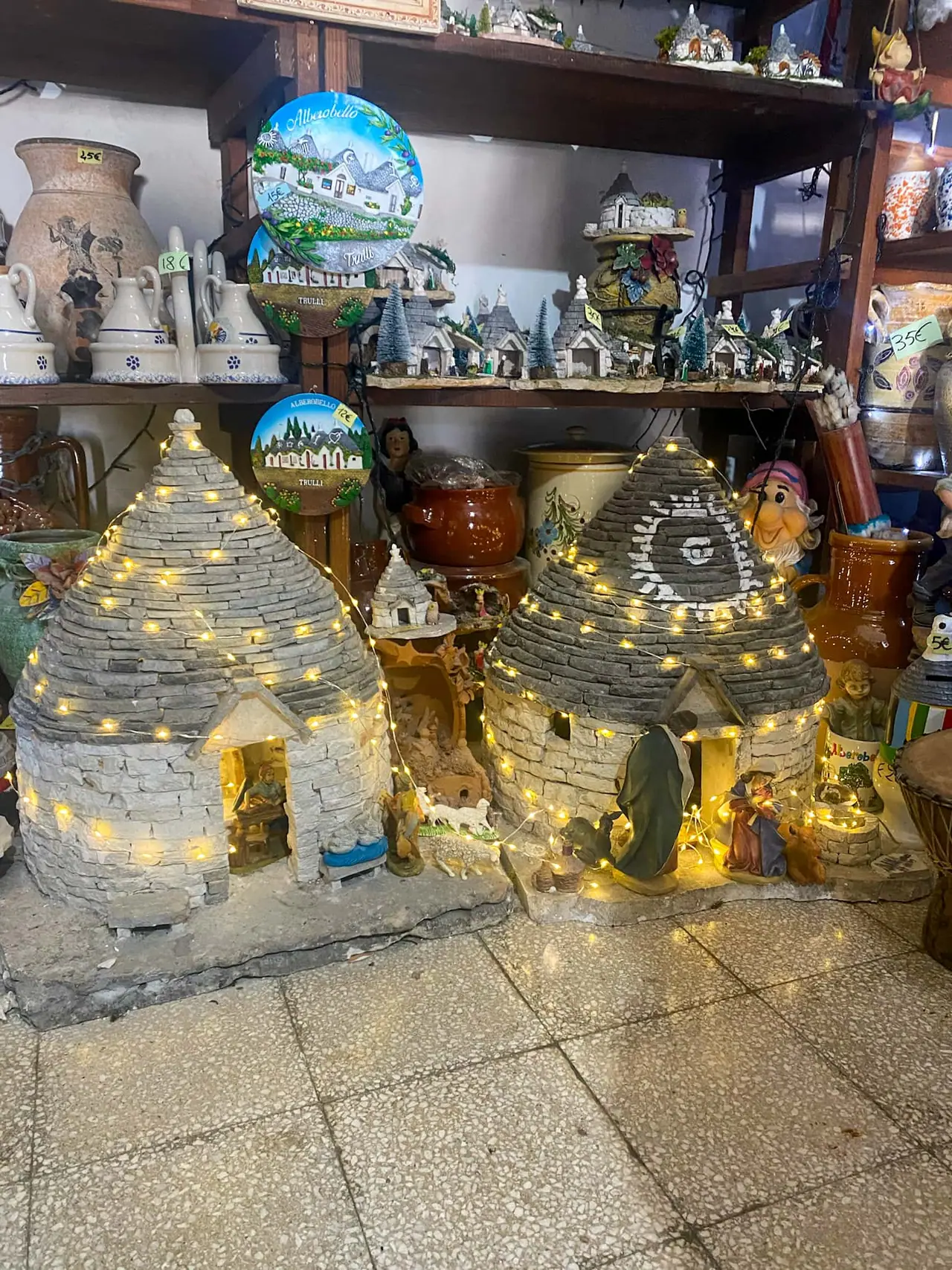 Svítící miniaturní trulli domečky a tradiční suvenýry z Alberobella v místním obchodě v historickém centru Apulie
