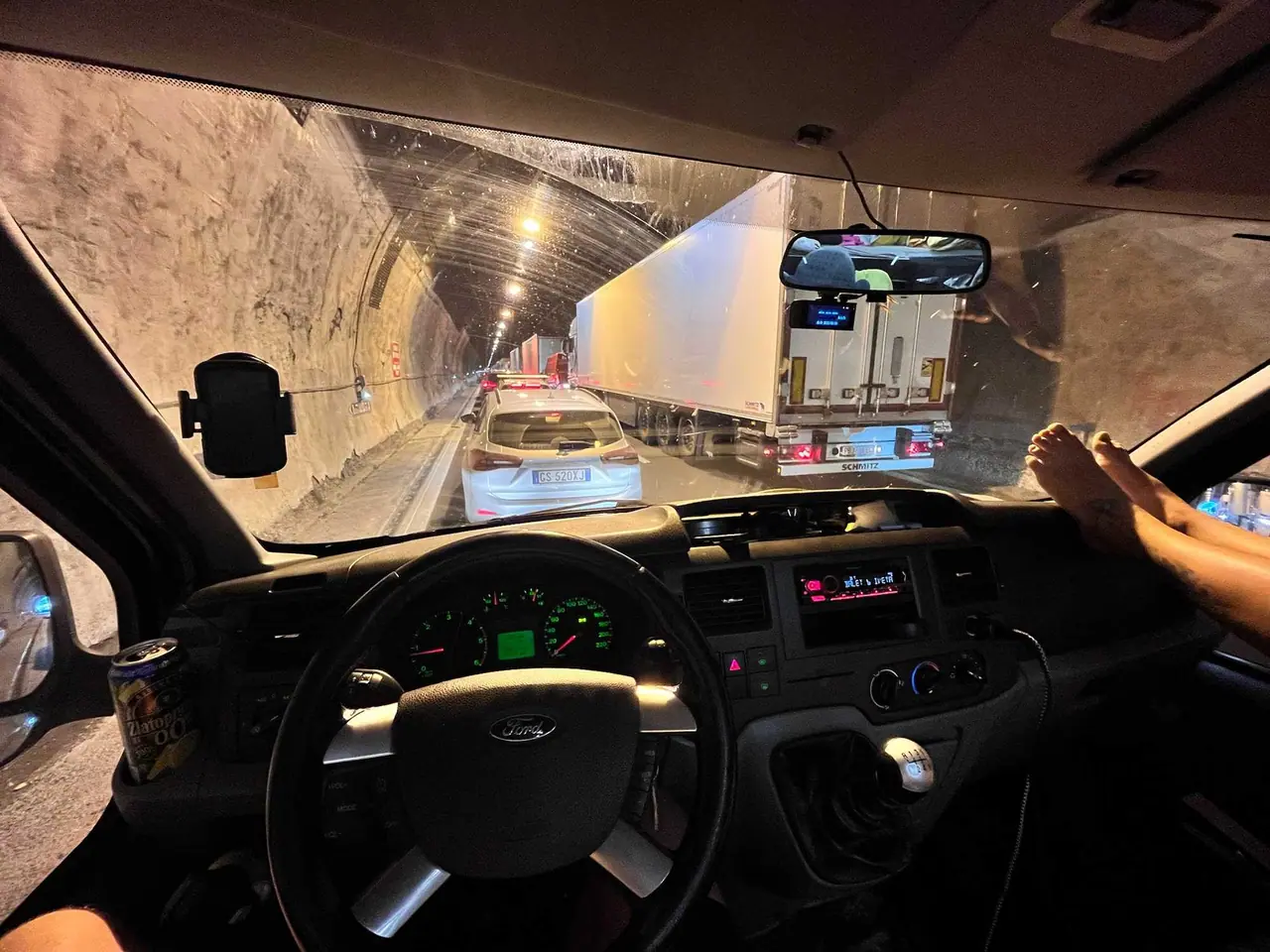 Pohled z kabiny našeho auta během jízdy tunelem na cestě domů ze San Marina, vpředu modré auto a kamion